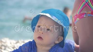 <strong>可爱</strong>的小<strong>宝宝</strong>，戴着一顶大<strong>帽子</strong>坐在海滩上微笑。